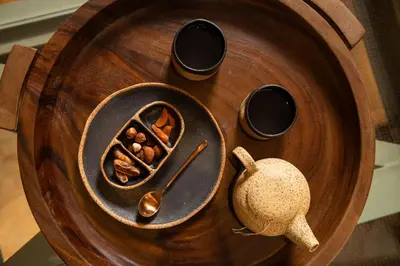 a wooden tray with a bowl of food and a spoon at Niche Hotel Athens in Athens