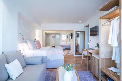 a room with a bed and a couch and a kitchen at Niche Hotel Athens in Athens