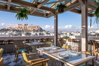 a restaurant with tables and chairs and a view of the city at Niche Hotel Athens in Athens