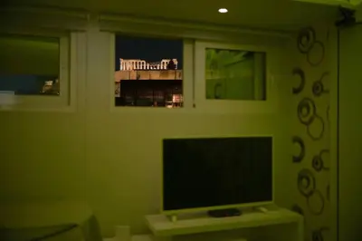 a living room with a flat screen tv and two windows at Acropolis Junior Suite in Athens