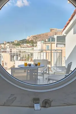 a circular window with a table and chairs on a balcony at Acropolis Junior Suite in Athens