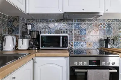 a kitchen with a microwave sitting on top of a counter at Alexander Apartments Airport in Spáta