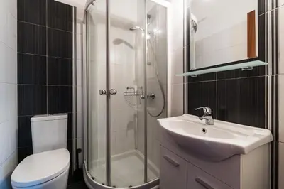 a bathroom with a shower and a sink and a toilet at Alexander Apartments Airport in Spáta