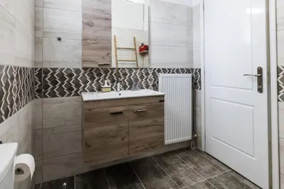a bathroom with a sink and a mirror at Alexander Apartments Airport in Spáta