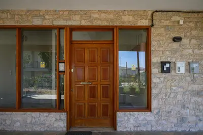 a wooden door on a building with windows at Alexander Apartments Airport in Spáta