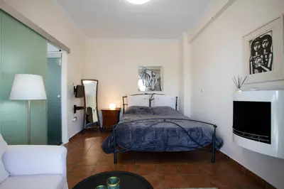 a bedroom with a bed and a couch and a tv at Romantic and cosy apartment in Athens