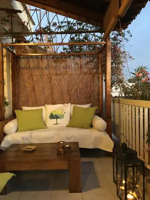 a bed on a porch with a wooden table at Romantic and cosy apartment in Athens