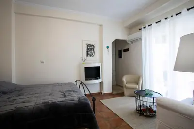 a bedroom with a bed and a tv and a couch at Romantic and cosy apartment in Athens