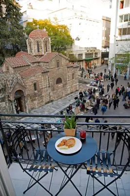 a plate of food on a table on a balcony at Four Streets Athens - Luxury Suites Apartments in Athens in Athens