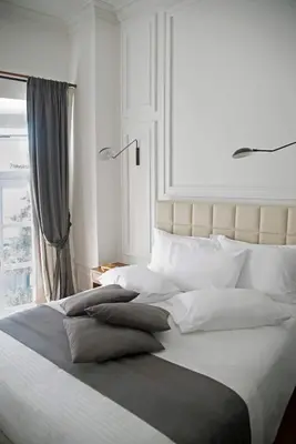 a bedroom with a large bed with pillows and a window at Four Streets Athens - Luxury Suites Apartments in Athens in Athens