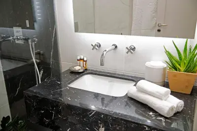a bathroom with a sink and a large mirror at Four Streets Athens - Luxury Suites Apartments in Athens in Athens