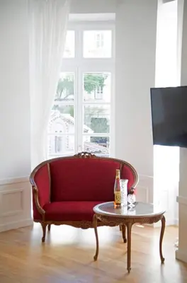 a red couch in a living room with a table at Four Streets Athens - Luxury Suites Apartments in Athens in Athens