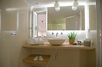 a bathroom with a sink and a large mirror at Four Streets Athens - Luxury Suites Apartments in Athens in Athens