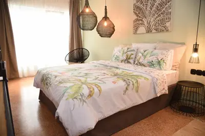 a bedroom with a bed with a white comforter and a window at CasaGreek Monastiraki - Athens in Athens