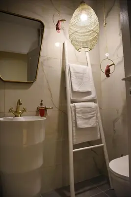 a bathroom with a towel ladder and a mirror at CasaGreek Monastiraki - Athens in Athens