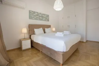 a bedroom with a large white bed and a lamp at Roomy and comfortable apartment near Acropolis by GHH in Athens