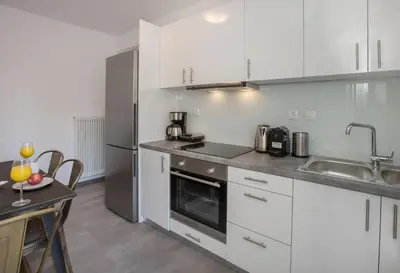 a kitchen with white cabinets and stainless steel appliances at Roomy and comfortable apartment near Acropolis by GHH in Athens