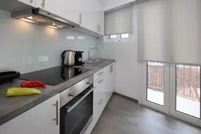 a kitchen with white cabinets and a counter top at Roomy and comfortable apartment near Acropolis by GHH in Athens