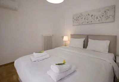 a bedroom with a white bed with towels on it at Roomy and comfortable apartment near Acropolis by GHH in Athens
