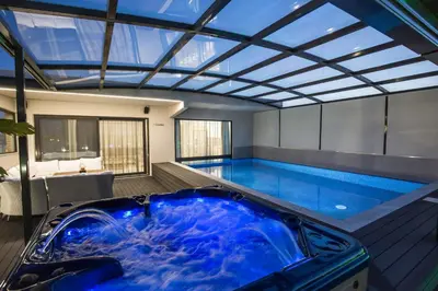 a large pool with a blue tub in a room at Zambelis Athens Penthouse Spa in Athens