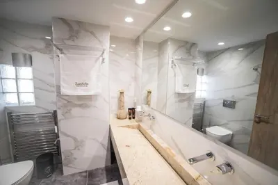 a white bathroom with a tub and a toilet at Zambelis Athens Penthouse Spa in Athens