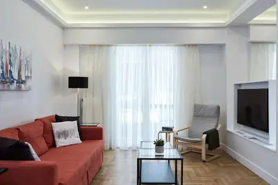 a living room with a red couch and a tv at Luxurious Spacious Apt next to Hilton Hotel in Athens