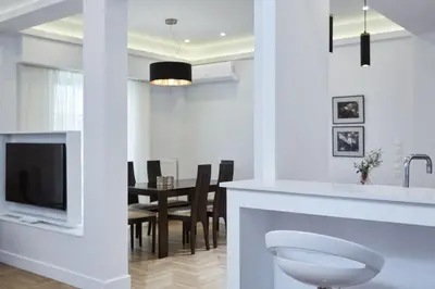 a kitchen and dining room with a white counter and a tv at Luxurious Spacious Apt next to Hilton Hotel in Athens