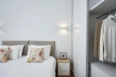 a bedroom with a bed with white sheets and pillows at Luxurious Spacious Apt next to Hilton Hotel in Athens