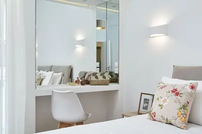 a bedroom with a white bed and a mirror at Luxurious Spacious Apt next to Hilton Hotel in Athens
