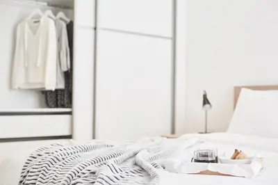 a white bed with a tray of food and a glass of wine at Modern Elegant Apt at Kolonaki in Athens