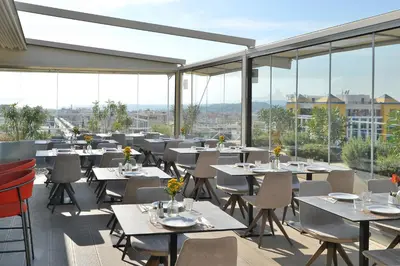 a restaurant with tables and chairs and large windows at Athenaeum Smart Hotel in Athens