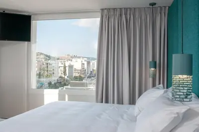a bedroom with a bed and a large window at Athenaeum Smart Hotel in Athens