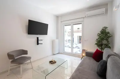 a living room with a couch and a tv on a wall at Sophisticated Modern Apt in Athens center in Athens