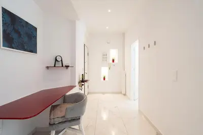 a white hallway with a red bench and a chair at Sophisticated Modern Apt in Athens center in Athens