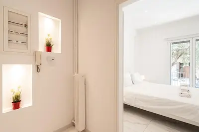 a white bedroom with a bed and a window at Sophisticated Modern Apt in Athens center in Athens