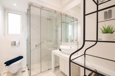 a white bathroom with a shower and a sink at Sophisticated Modern Apt in Athens center in Athens