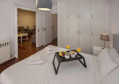 a room with a white bed with a tray of fruit on it at Charming Apartment few steps from Acropolis by GHH in Athens