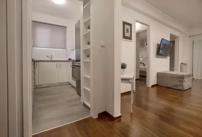 a kitchen and a living room with a table and a couch at Charming Apartment few steps from Acropolis by GHH in Athens