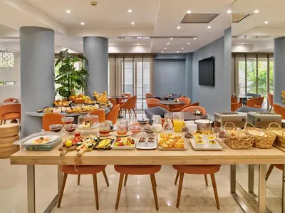 a table with food on it in a restaurant at Phidias Piraeus Hotel in Piraeus