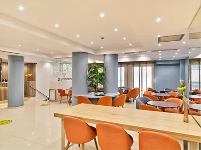 a lobby with tables and chairs in a building at Phidias Piraeus Hotel in Piraeus