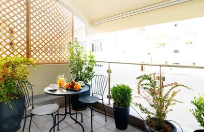 a balcony with a table and chairs and plants at Phidias Piraeus Hotel in Piraeus