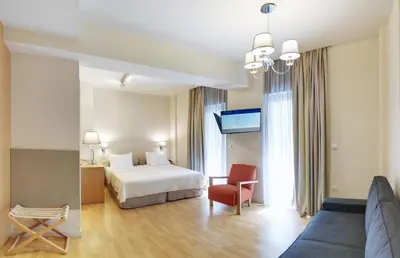 a hotel room with a bed and a couch at Phidias Piraeus Hotel in Piraeus
