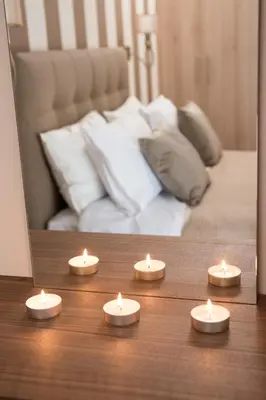 four candles sitting on a table in front of a bed at AT.thea ATHENS BOUTIQUE APARTMENTS in Athens