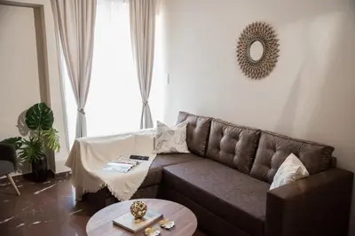 a living room with a brown couch and a table at AT.thea ATHENS BOUTIQUE APARTMENTS in Athens