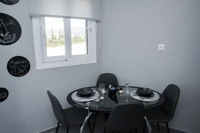 a dining room table with black chairs and a window at AT.thea ATHENS BOUTIQUE APARTMENTS in Athens