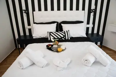a white bed with a tray of food on it at AT.thea ATHENS BOUTIQUE APARTMENTS in Athens