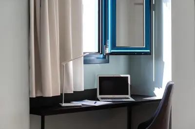 a laptop computer sitting on a desk under a window at Athens One Smart Hotel in Athens