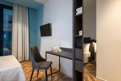 a room with a bed and a desk and a chair at Athens One Smart Hotel in Athens