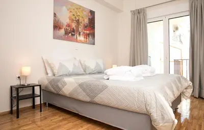 a bedroom with a bed with white sheets and pillows at Metro Fix Cosy Apartment in Athens