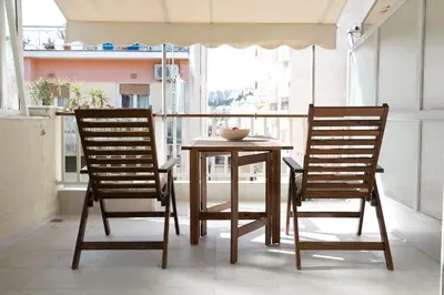 two chairs and a table on a balcony at Metro Fix Cosy Apartment in Athens
